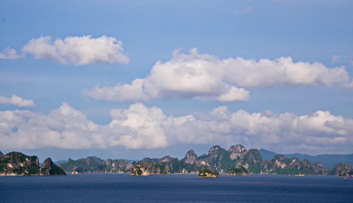 Wide view of karsts under a blue sky in Bai Tu Long Bay, Halong Bay cruise
