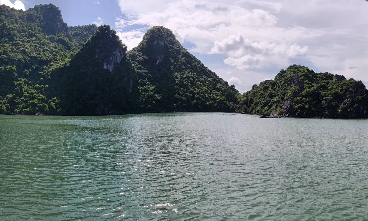 Dark karst peaks above calm water in Lan Ha Bay on a Halong Bay cruise