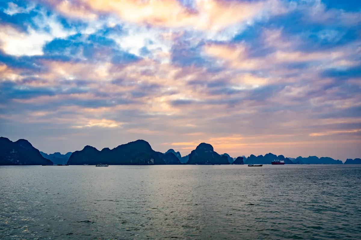 Colourful sunset sky over the karsts of Ha Long Bay, seen on a Ha Long Bay junk boat cruise