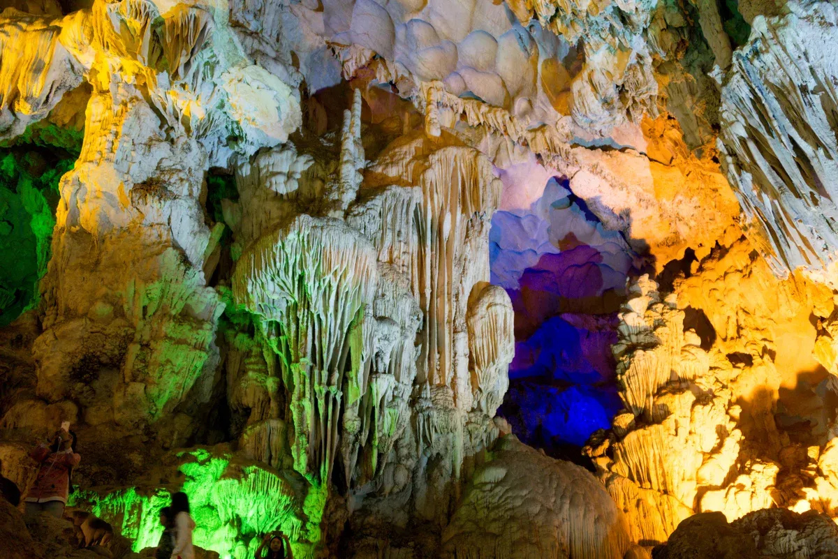 Colourful lit stalactites inside Thien Cung Cave on a Ha Long Bay junk boat cruise